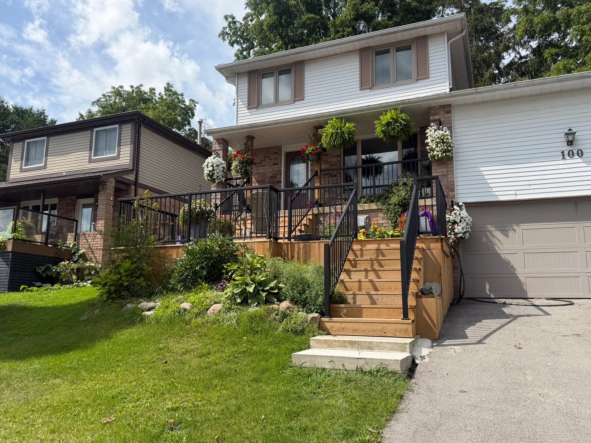 Finished front deck with wood stairs and black railing