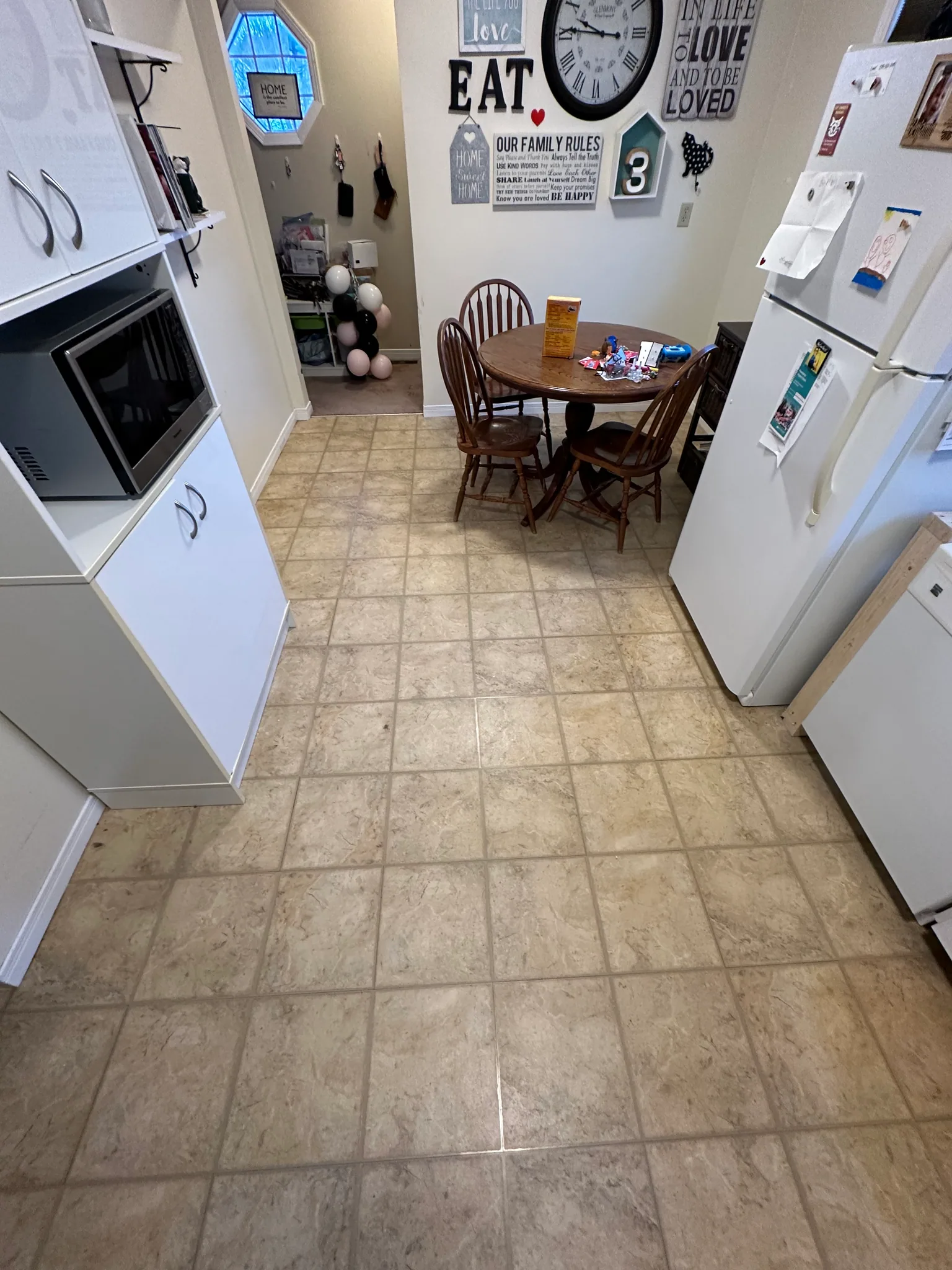 Beige kitchen floor tiles between the cabinets and dining area