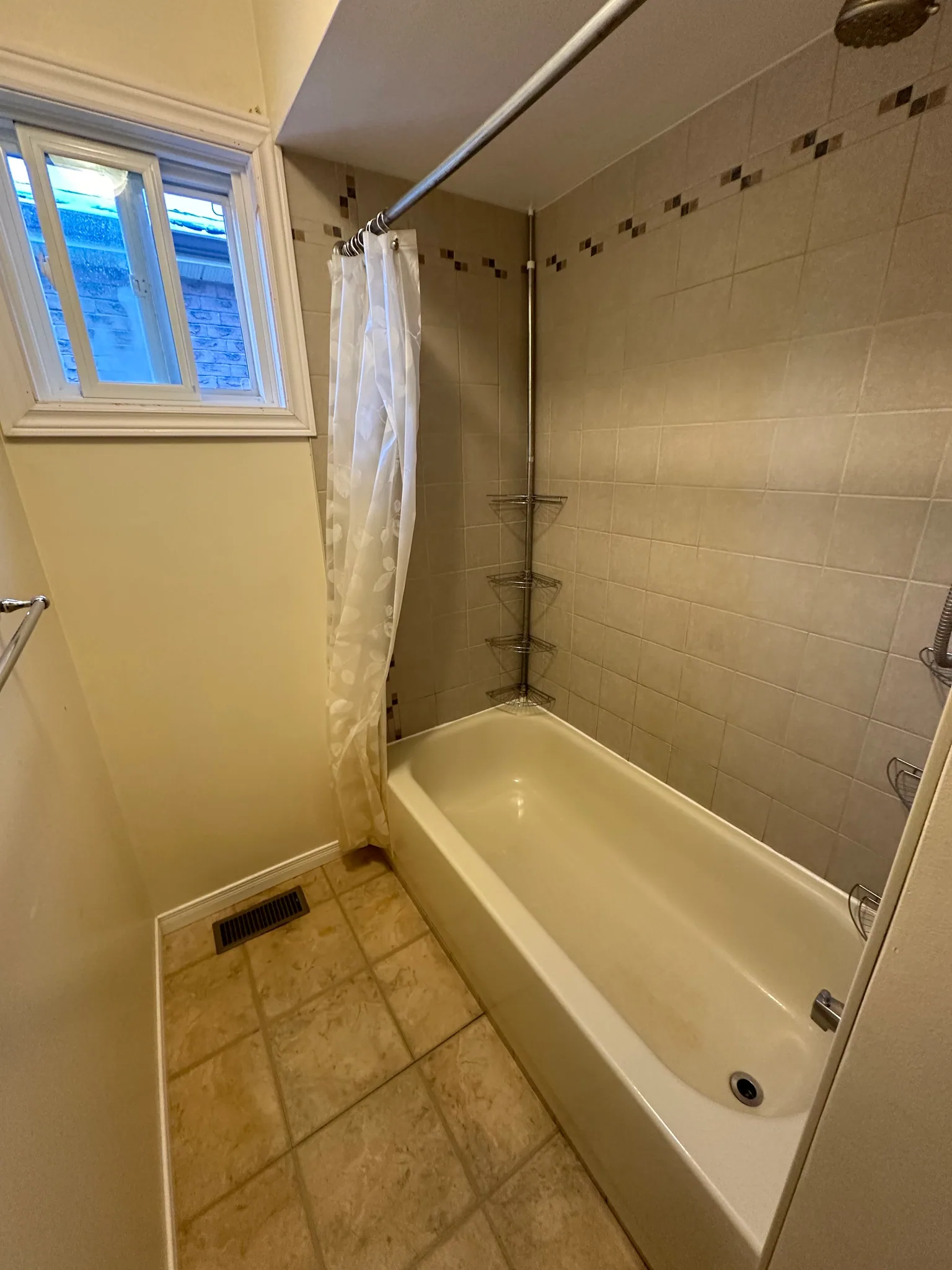 Bathtub surround with large wall tiles and a mosaic border